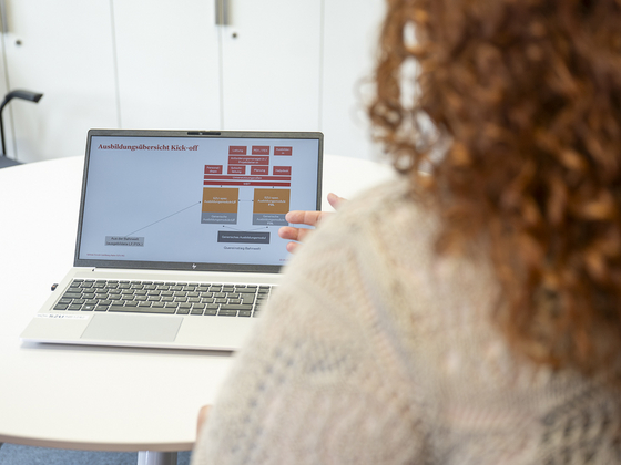 Frau erklärt etwas am Laptop