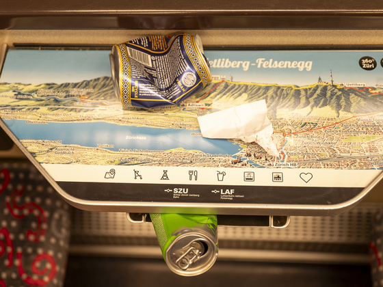 leere Dosen und Abfall neben Eimer